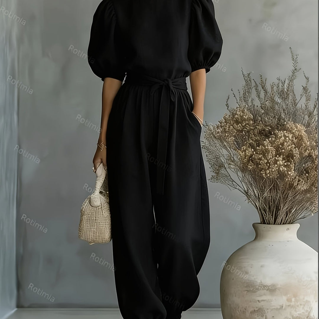 Jumpsuit i boheme-stil med pufærmer og bindebånd i taljen. Har sidelommer for bekvemmelighed, pasform og behagelig afslappet brug.