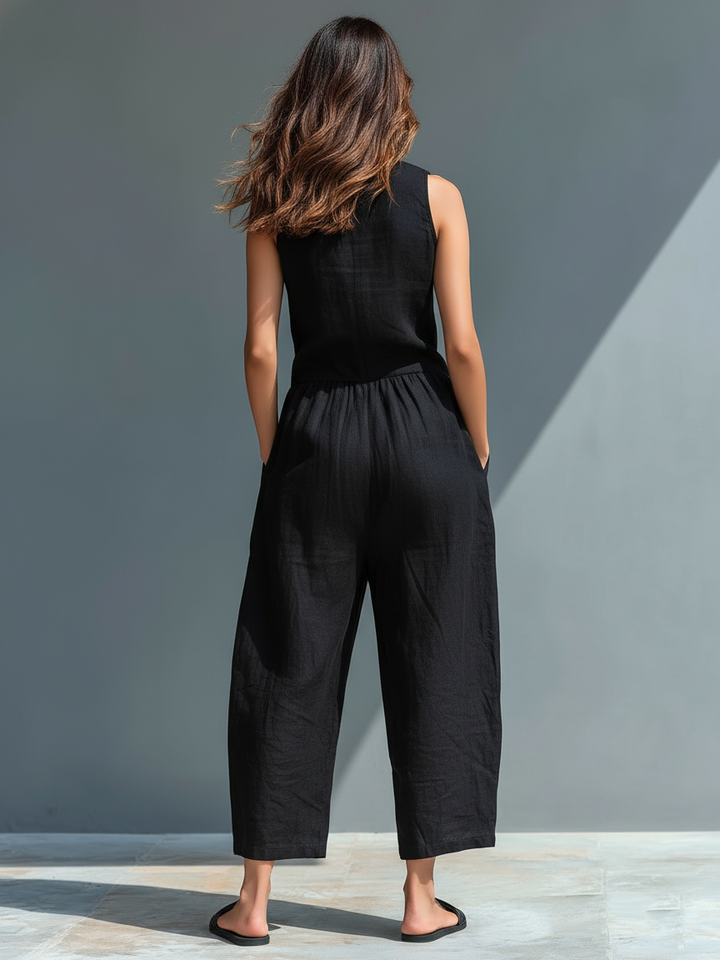 Minimalistisk damejumpsuit i hørblanding med knaplukning og stand-up-krave, ærmeløs og løs MDZ2725A5Y